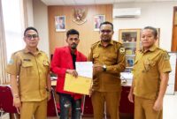 Ketua GMNI Mimika, Deni Dokainubun saat menyerahkan dokumen pengaduan kepada Kepala Inspektorat Mimika, Septinus Timang