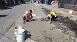 Warga menambal jalan berlubang secara swadaya di Jalan Pendidikan Jalur 1, Kelurahan Otomona, Timika, Minggu (21/12).